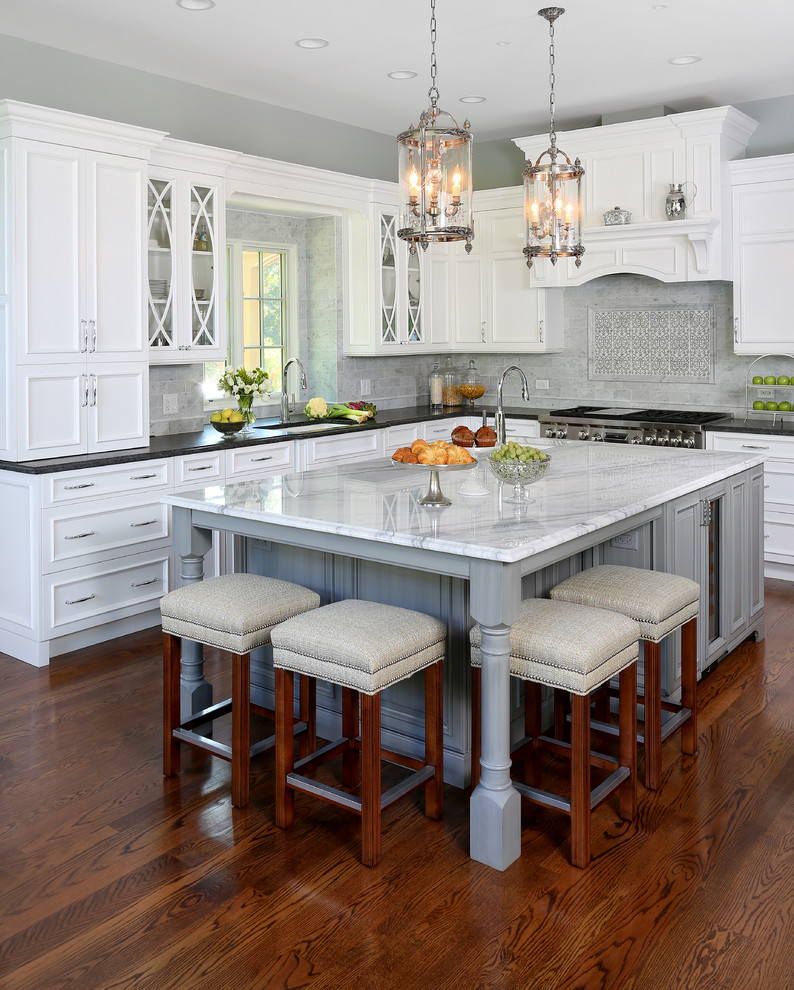 Inspiration for a large timeless l-shaped dark wood floor eat-in kitchen remodel in Chicago with an undermount sink, white cabinets, granite countertops, gray backsplash, stone tile backsplash, stainless steel appliances, an island and recessed-panel cabinets