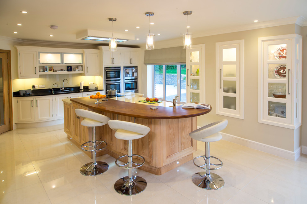 Inspiration for a transitional kitchen remodel in Cork with recessed-panel cabinets, white cabinets and an island