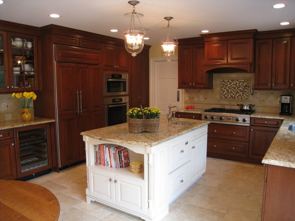 Klassisk inredning av ett mellanstort kök, med en nedsänkt diskho, luckor med upphöjd panel, skåp i mellenmörkt trä, granitbänkskiva, beige stänkskydd, stänkskydd i stenkakel, rostfria vitvaror, klinkergolv i porslin och en köksö