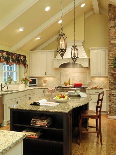 Inredning av ett klassiskt kök, med en undermonterad diskho, granitbänkskiva, beige stänkskydd och färgglada vitvaror