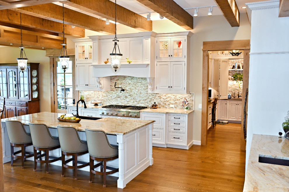 This is an example of a large traditional u-shaped kitchen/diner in Other with a submerged sink, raised-panel cabinets, white cabinets, quartz worktops, multi-coloured splashback, ceramic splashback, stainless steel appliances, medium hardwood flooring, an island, brown floors and beige worktops.