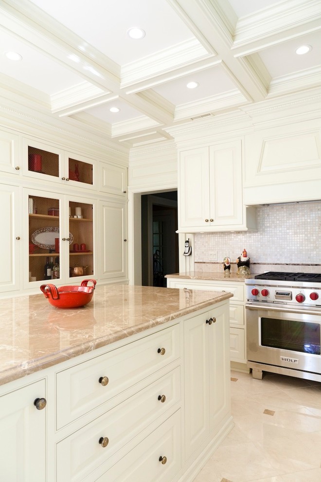 Exempel på ett avskilt, mellanstort klassiskt u-kök, med en enkel diskho, luckor med upphöjd panel, vita skåp, marmorbänkskiva, beige stänkskydd, stänkskydd i keramik, rostfria vitvaror, klinkergolv i keramik och en köksö