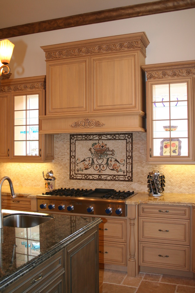 Eat-in kitchen - large mediterranean l-shaped travertine floor eat-in kitchen idea in Miami with an undermount sink, raised-panel cabinets, light wood cabinets, granite countertops, beige backsplash, mosaic tile backsplash, stainless steel appliances and an island