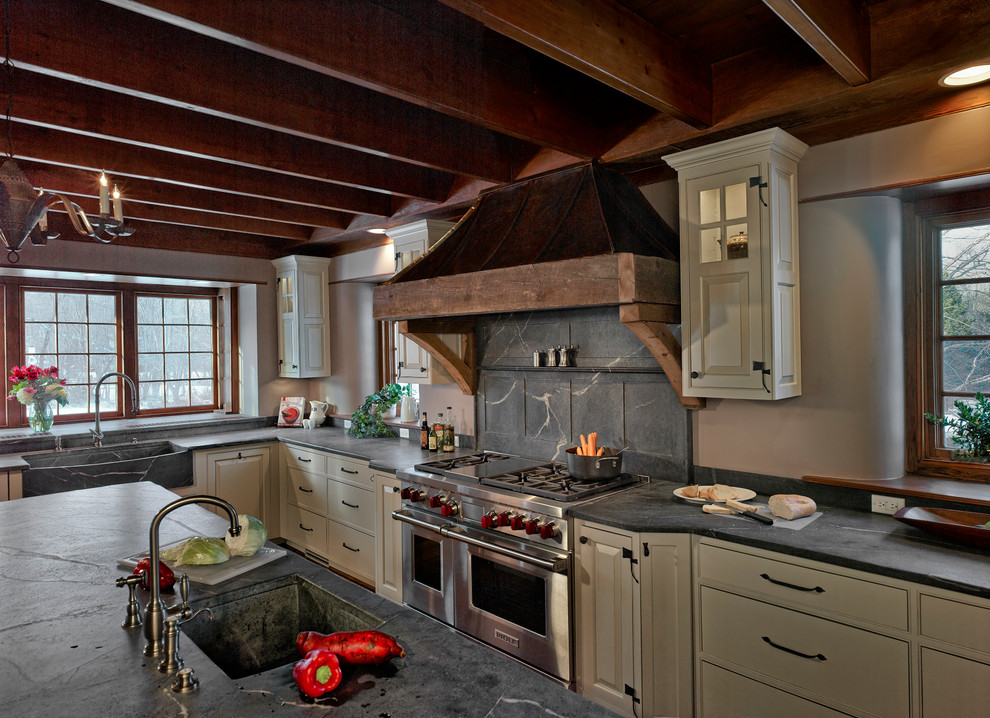 Large rural l-shaped kitchen/diner in Philadelphia with a double-bowl sink, soapstone worktops, grey splashback, stainless steel appliances, medium hardwood flooring and an island.
