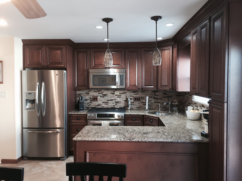 Inspiration for a mid-sized timeless u-shaped ceramic tile enclosed kitchen remodel in New York with an undermount sink, raised-panel cabinets, dark wood cabinets, granite countertops, multicolored backsplash, matchstick tile backsplash, stainless steel appliances and a peninsula