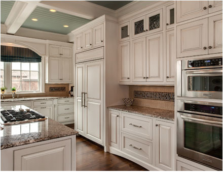 Foto de cocina clásica con puertas de armario blancas, electrodomésticos de acero inoxidable y una isla