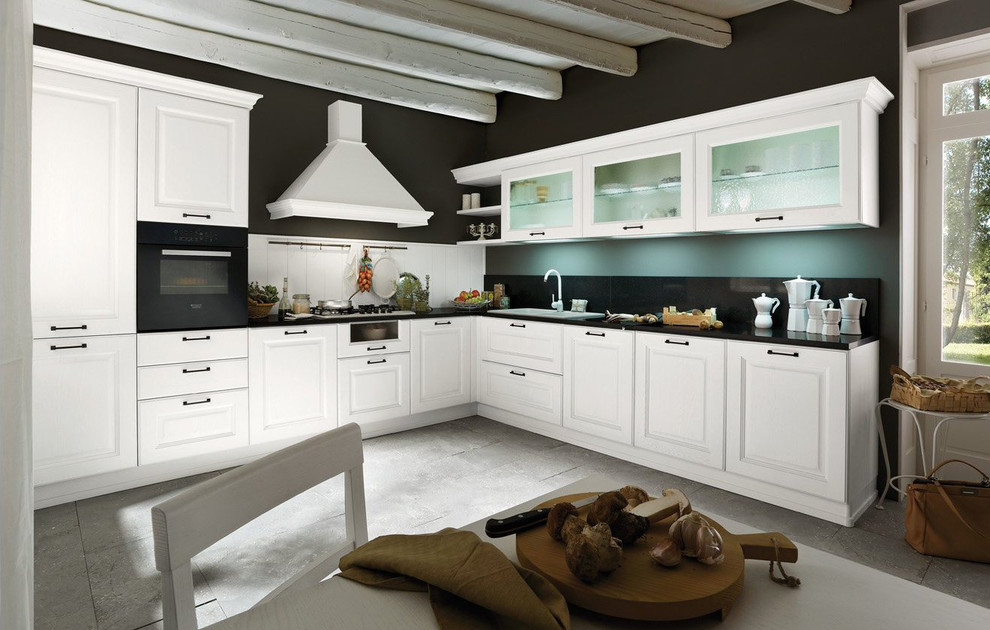 Inspiration för ett avskilt, stort vintage l-kök, med luckor med infälld panel, vita skåp, bänkskiva i kvarts, svart stänkskydd, svarta vitvaror, skiffergolv och grått golv