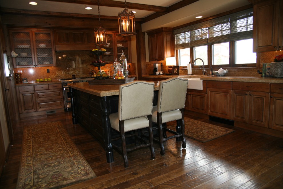 Klassisk inredning av ett avskilt, stort l-kök, med en rustik diskho, luckor med upphöjd panel, skåp i mellenmörkt trä, granitbänkskiva, flerfärgad stänkskydd, stänkskydd i sten, rostfria vitvaror, mörkt trägolv och en köksö
