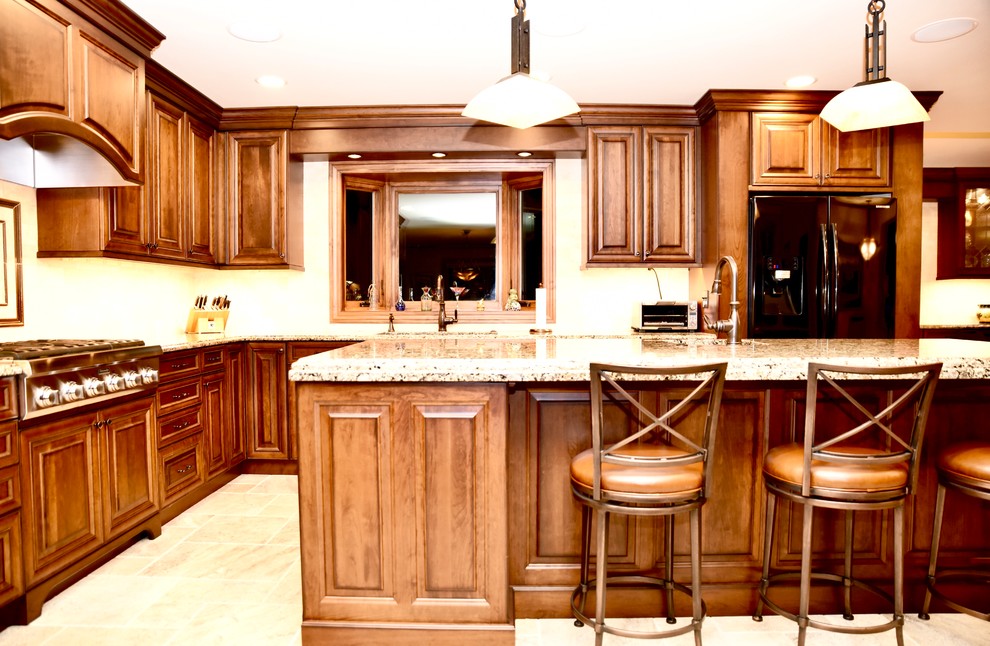 Exempel på ett stort klassiskt beige beige kök, med en dubbel diskho, luckor med upphöjd panel, skåp i mellenmörkt trä, granitbänkskiva, beige stänkskydd, stänkskydd i travertin, svarta vitvaror, travertin golv, en köksö och beiget golv