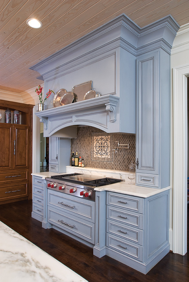 Klassisk inredning av ett stort kök, med luckor med upphöjd panel, brunt stänkskydd, stänkskydd i mosaik och rostfria vitvaror