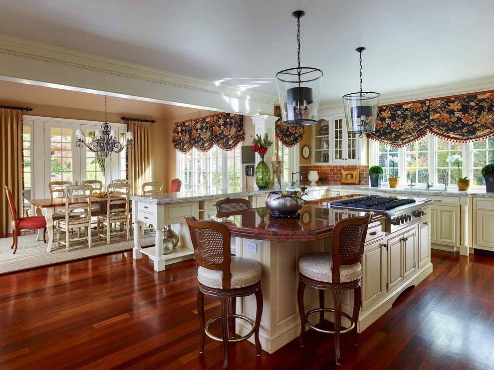Example of a huge classic u-shaped medium tone wood floor open concept kitchen design in Philadelphia with an undermount sink, raised-panel cabinets, yellow cabinets, stainless steel appliances and an island
