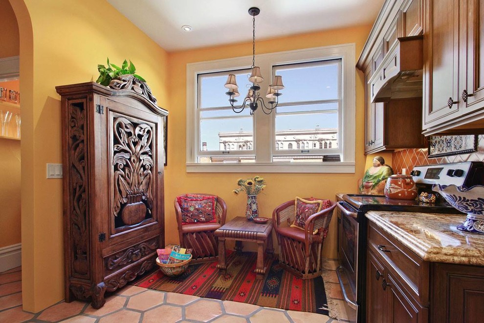 Example of a mid-sized southwest u-shaped terra-cotta tile enclosed kitchen design in San Francisco with an undermount sink, recessed-panel cabinets, medium tone wood cabinets, granite countertops, orange backsplash, ceramic backsplash, stainless steel appliances and no island