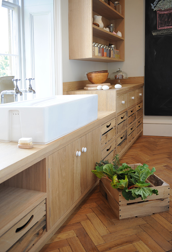 Offene, Große Moderne Küche in L-Form mit flächenbündigen Schrankfronten, Marmor-Arbeitsplatte, Kücheninsel und hellen Holzschränken in London