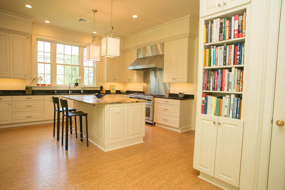 This is an example of a large contemporary u-shaped kitchen in New Orleans with a submerged sink, raised-panel cabinets, white cabinets, granite worktops, stainless steel appliances, cork flooring and an island.