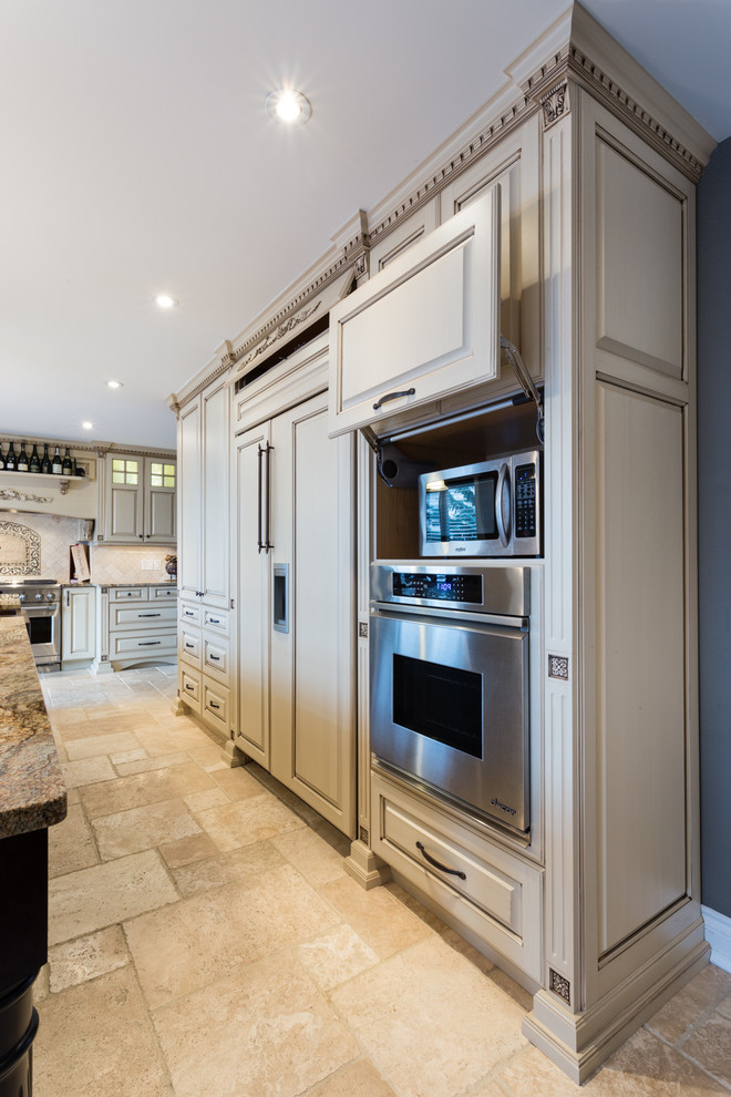 Design ideas for a large classic kitchen in Other with raised-panel cabinets, beige cabinets, granite worktops, beige splashback, stone tiled splashback, integrated appliances and travertine flooring.