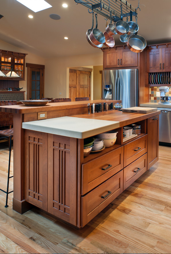 Mid-sized arts and crafts l-shaped medium tone wood floor and brown floor kitchen photo in Other with a farmhouse sink, shaker cabinets, medium tone wood cabinets, wood countertops, multicolored backsplash, ceramic backsplash, stainless steel appliances and an island
