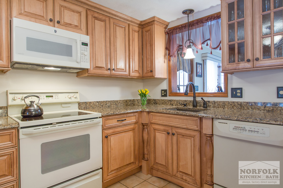 Klassisk inredning av ett mellanstort kök, med en undermonterad diskho, luckor med upphöjd panel, skåp i ljust trä, granitbänkskiva, vita vitvaror och en halv köksö