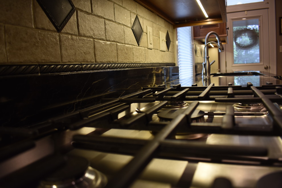 Idéer för att renovera ett avskilt, mellanstort vintage u-kök, med en dubbel diskho, luckor med upphöjd panel, skåp i mellenmörkt trä, granitbänkskiva, beige stänkskydd, rostfria vitvaror, klinkergolv i keramik, en köksö och beiget golv