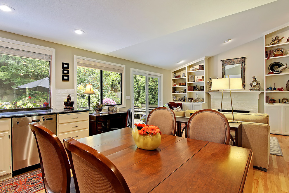 Example of a mid-sized classic medium tone wood floor eat-in kitchen design in Seattle with flat-panel cabinets, beige cabinets, white backsplash, ceramic backsplash, stainless steel appliances and no island