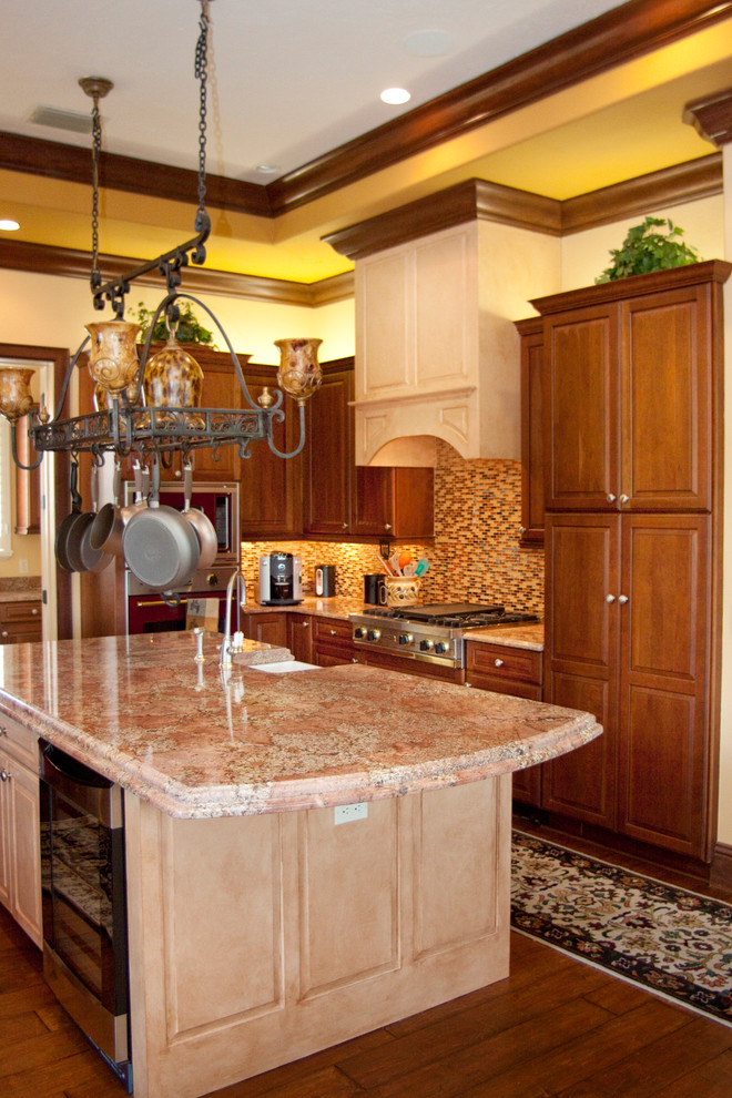 Klassisk inredning av ett mellanstort kök, med en rustik diskho, luckor med upphöjd panel, skåp i mörkt trä, granitbänkskiva, flerfärgad stänkskydd, rostfria vitvaror och mörkt trägolv