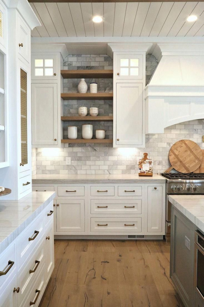 Inspiration för stora klassiska vitt kök, med en rustik diskho, luckor med profilerade fronter, vita skåp, marmorbänkskiva, vitt stänkskydd, stänkskydd i stenkakel, rostfria vitvaror, ljust trägolv, en köksö och brunt golv