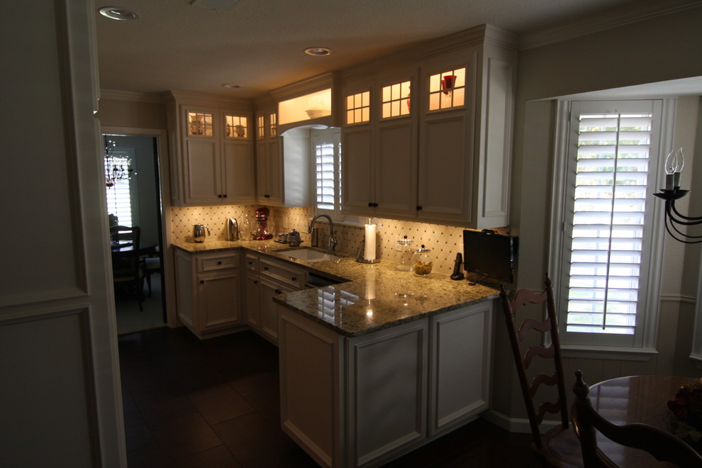 Bild på ett stort vintage kök, med en undermonterad diskho, luckor med infälld panel, vita skåp, granitbänkskiva, beige stänkskydd, stänkskydd i marmor, rostfria vitvaror, klinkergolv i porslin och brunt golv