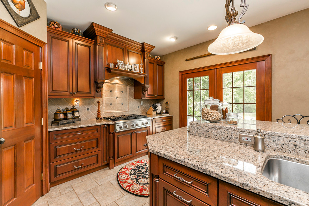 Example of a mid-sized classic l-shaped ceramic tile and beige floor eat-in kitchen design in Philadelphia with an undermount sink, raised-panel cabinets, medium tone wood cabinets, granite countertops, beige backsplash, ceramic backsplash, stainless steel appliances and an island