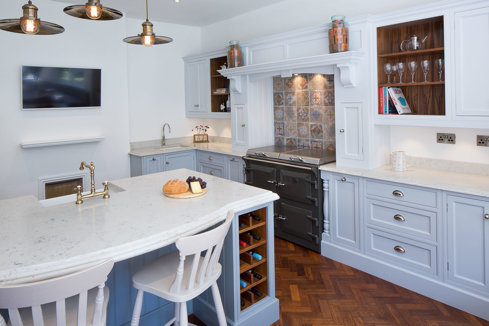 This is an example of a classic kitchen in Dorset with shaker cabinets, blue cabinets, granite worktops, multi-coloured splashback, coloured appliances, medium hardwood flooring and an island.