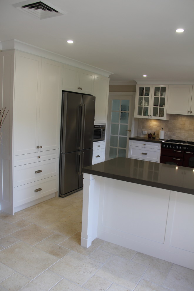 Design ideas for a medium sized traditional u-shaped open plan kitchen in Sydney with a double-bowl sink, shaker cabinets, beige cabinets, engineered stone countertops, beige splashback, travertine splashback, travertine flooring, no island and beige floors.
