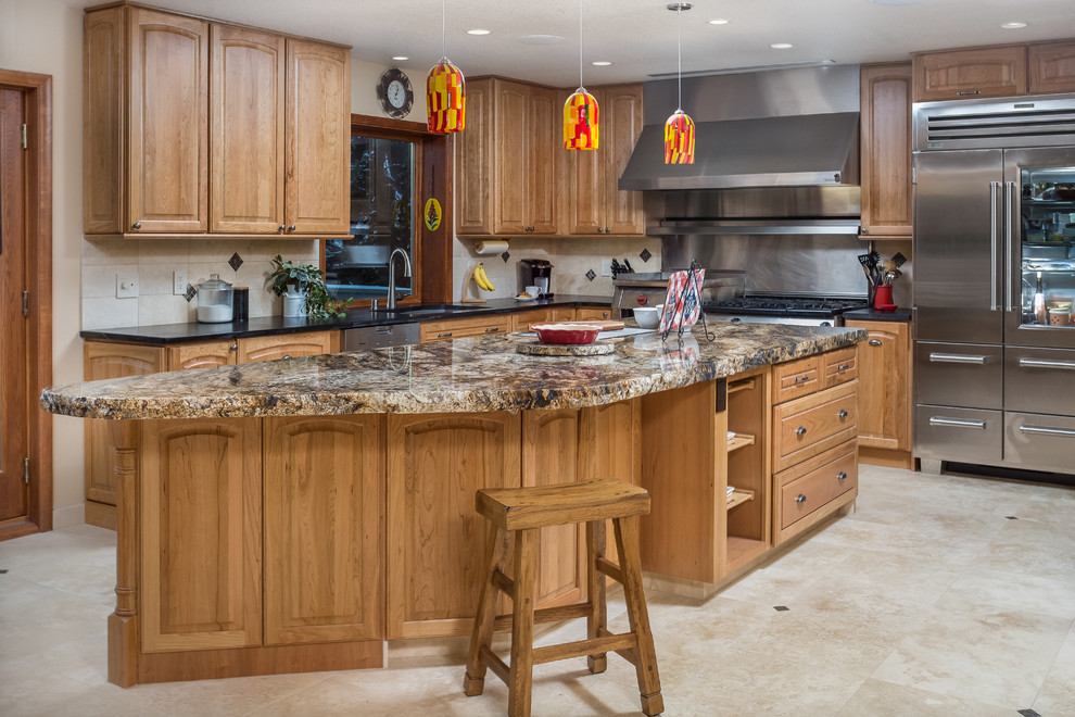 Exempel på ett stort klassiskt kök, med en undermonterad diskho, luckor med upphöjd panel, skåp i mellenmörkt trä, granitbänkskiva, beige stänkskydd, stänkskydd i stenkakel, rostfria vitvaror, travertin golv och en köksö