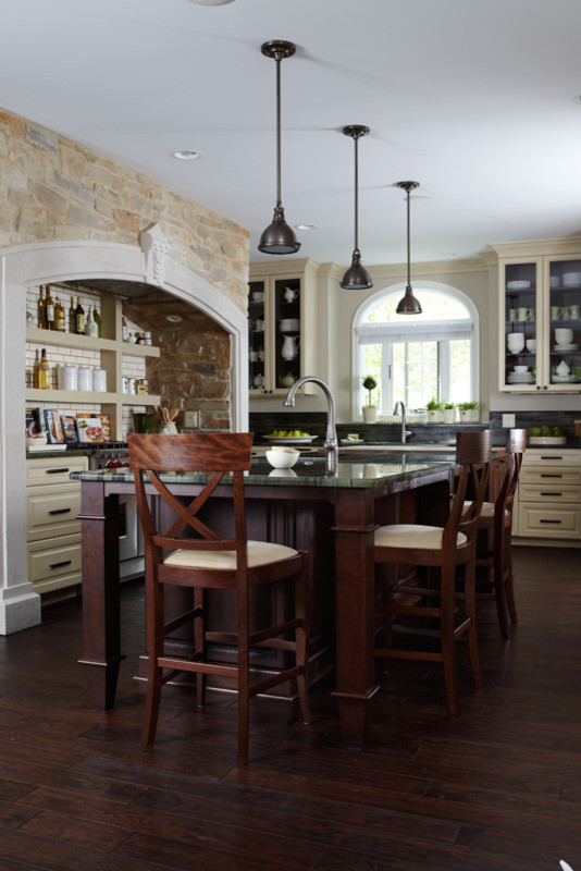 Inspiration for a large rustic u-shaped dark wood floor kitchen remodel in Detroit with raised-panel cabinets, yellow cabinets, marble countertops, stainless steel appliances and an island