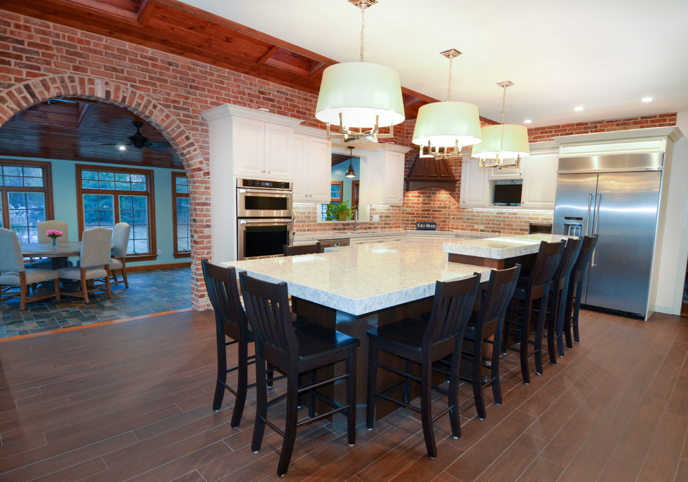 Example of a large urban l-shaped dark wood floor and brown floor enclosed kitchen design in Boston with an undermount sink, raised-panel cabinets, white cabinets, granite countertops, red backsplash, brick backsplash, stainless steel appliances, an island and white countertops