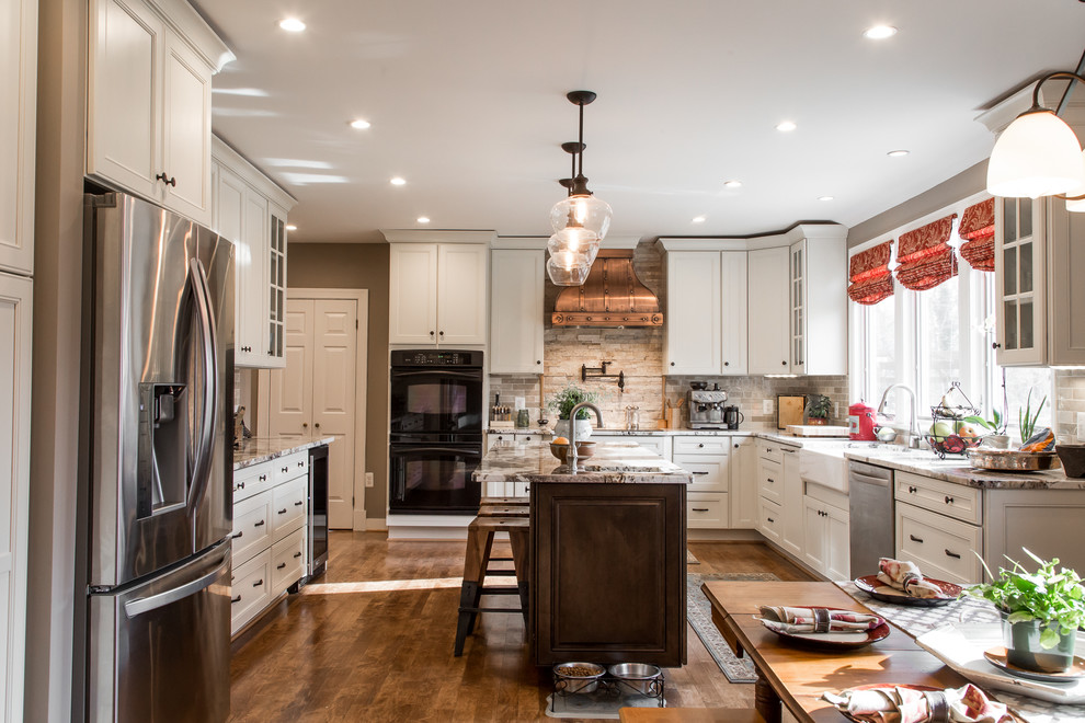 This is an example of a large traditional u-shaped kitchen/diner in Tampa with a belfast sink, recessed-panel cabinets, white cabinets, granite worktops, stone tiled splashback, medium hardwood flooring and an island.
