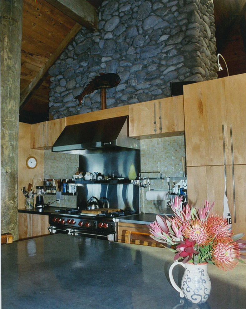 Esempio di un ampio cucina con isola centrale tropicale con lavello sottopiano, ante lisce, ante in legno chiaro, top in cemento, elettrodomestici in acciaio inossidabile, pavimento in travertino e paraspruzzi con piastrelle in pietra