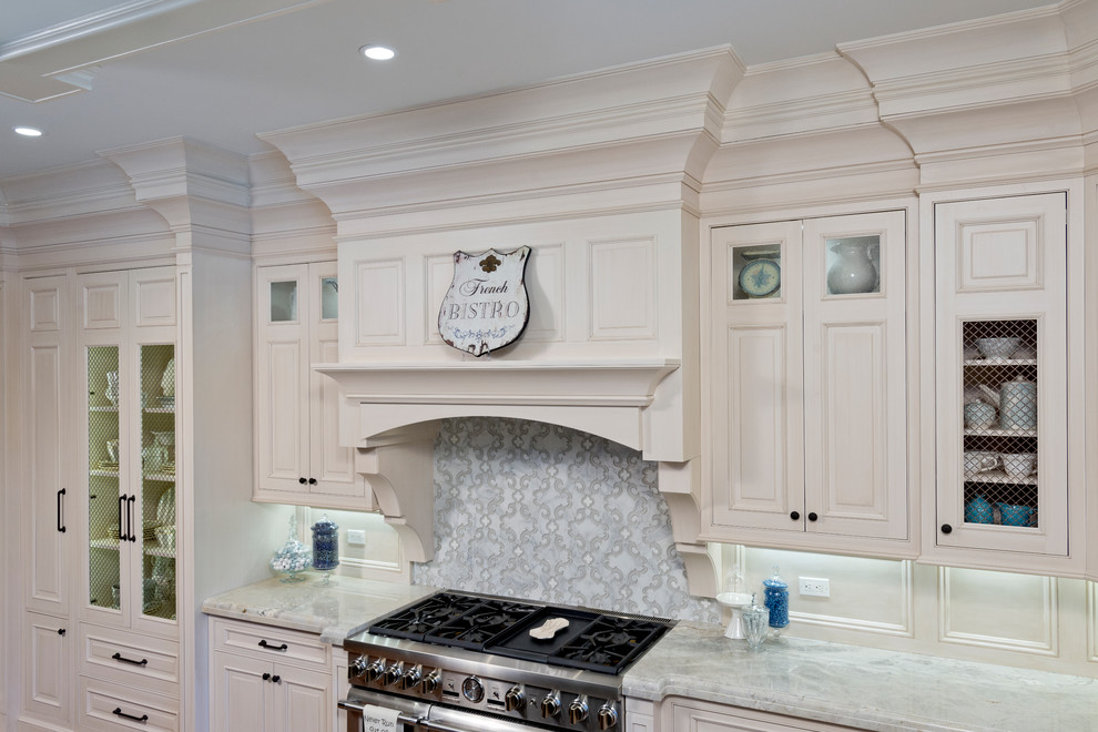 Example of a classic l-shaped medium tone wood floor open concept kitchen design in New York with a single-bowl sink, raised-panel cabinets, white cabinets, window backsplash, stainless steel appliances and an island