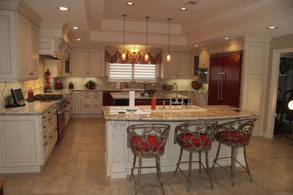 Eat-in kitchen - huge traditional u-shaped travertine floor and beige floor eat-in kitchen idea in Houston with white cabinets, beige backsplash, colored appliances, two islands, raised-panel cabinets, granite countertops, stone tile backsplash and a triple-bowl sink