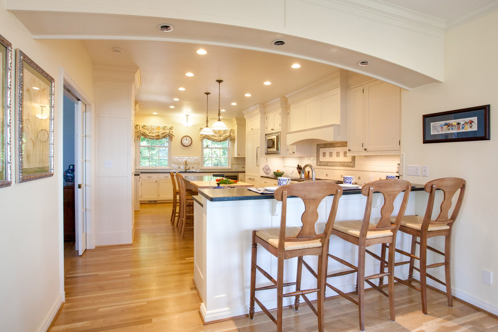 Photo of a traditional kitchen/diner in Portland with recessed-panel cabinets and white cabinets.