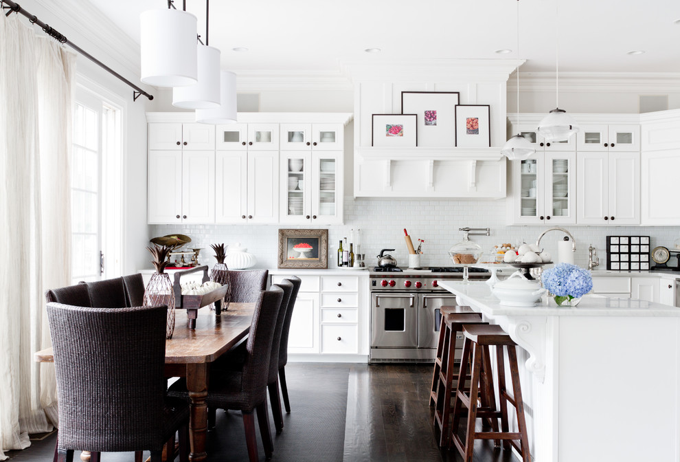 Klassische Wohnküche mit Schrankfronten mit vertiefter Füllung, weißen Schränken, Küchenrückwand in Weiß, Rückwand aus Metrofliesen und Küchengeräten aus Edelstahl in Sonstige