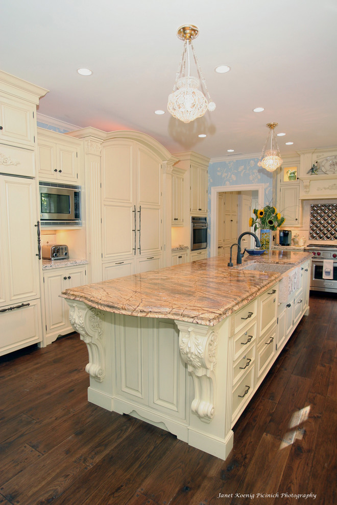 Exempel på ett klassiskt kök, med rostfria vitvaror, en rustik diskho, luckor med upphöjd panel och beige skåp