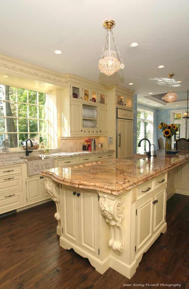 Klassisk inredning av ett kök, med en rustik diskho, luckor med upphöjd panel och beige skåp