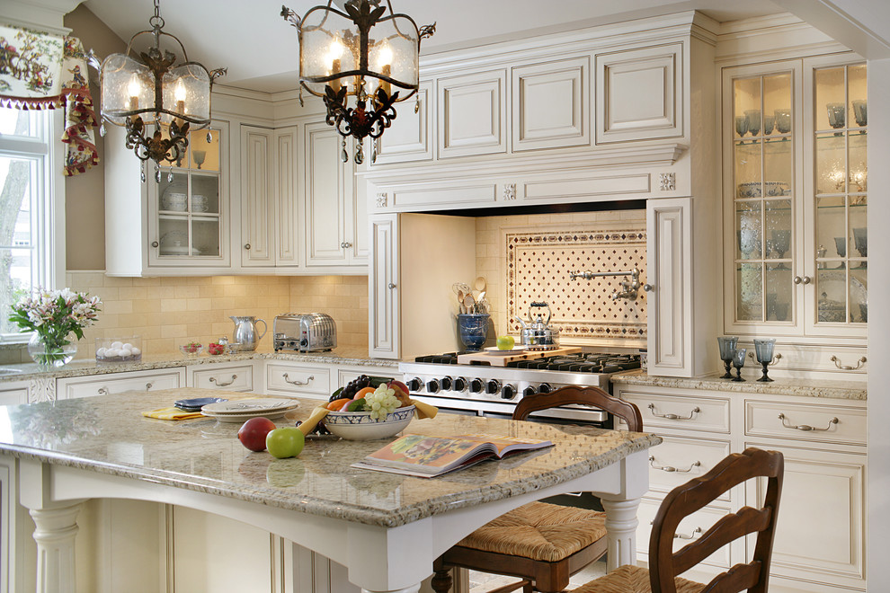 Foto de cocina tradicional con armarios con paneles con relieve, puertas de armario beige, salpicadero beige y electrodomésticos de acero inoxidable