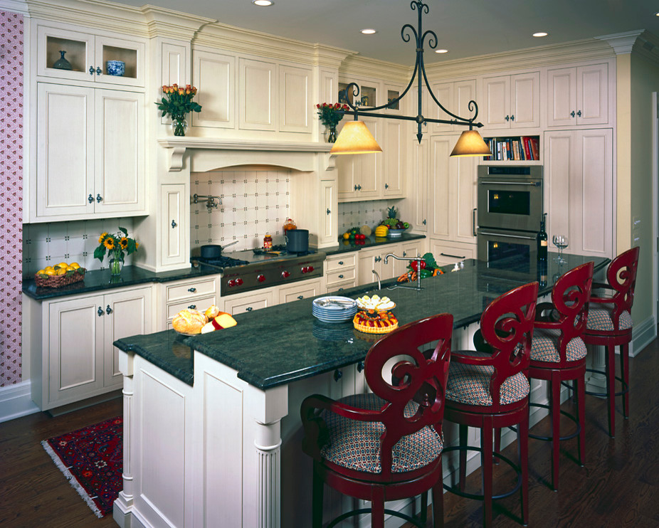 Exempel på ett klassiskt kök, med luckor med profilerade fronter, vita skåp, granitbänkskiva, vitt stänkskydd, stänkskydd i keramik, integrerade vitvaror, mörkt trägolv och en köksö