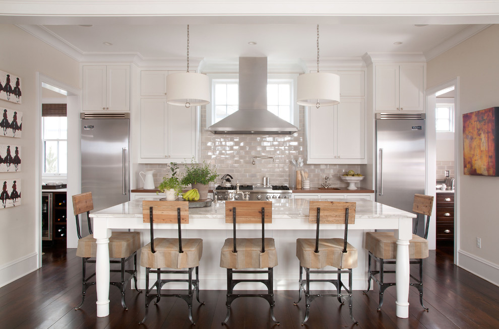 Elegant galley kitchen photo in Denver with stainless steel appliances, marble countertops, recessed-panel cabinets, white cabinets and glass tile backsplash