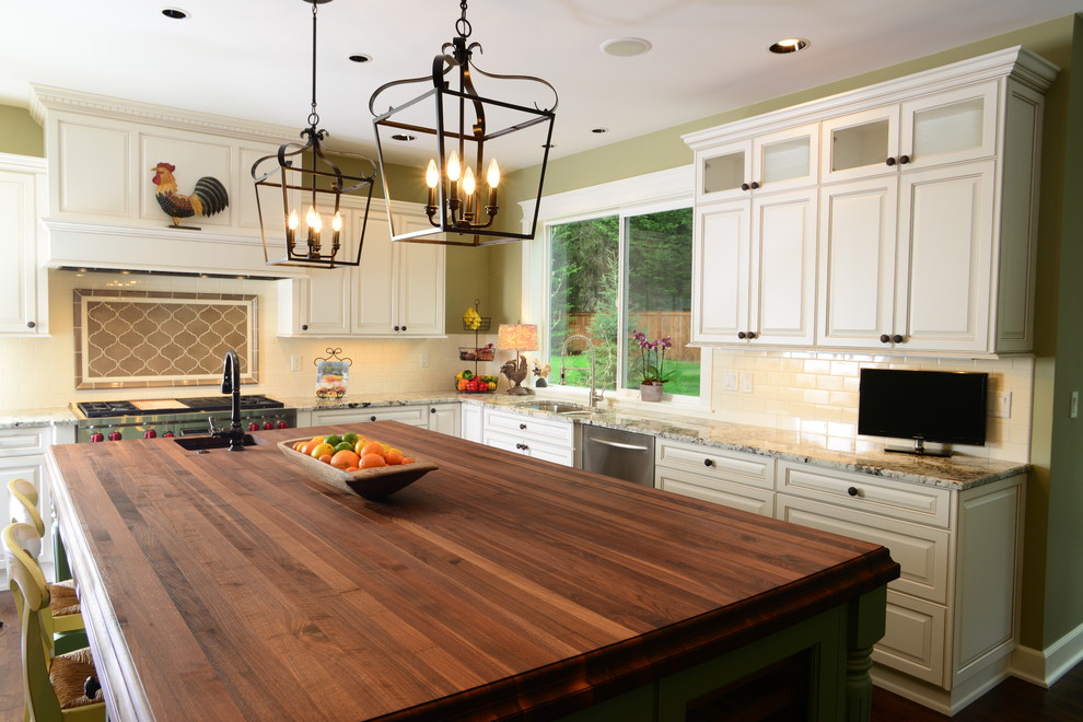 Eat-in kitchen - large traditional u-shaped medium tone wood floor eat-in kitchen idea in Seattle with an undermount sink, raised-panel cabinets, white cabinets, wood countertops, white backsplash, subway tile backsplash, stainless steel appliances and an island