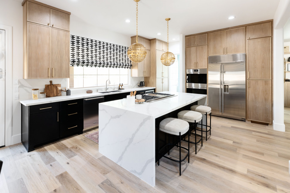Design ideas for a contemporary l-shaped kitchen in Phoenix with a submerged sink, flat-panel cabinets, medium wood cabinets, stainless steel appliances, light hardwood flooring, an island, beige floors and white worktops.