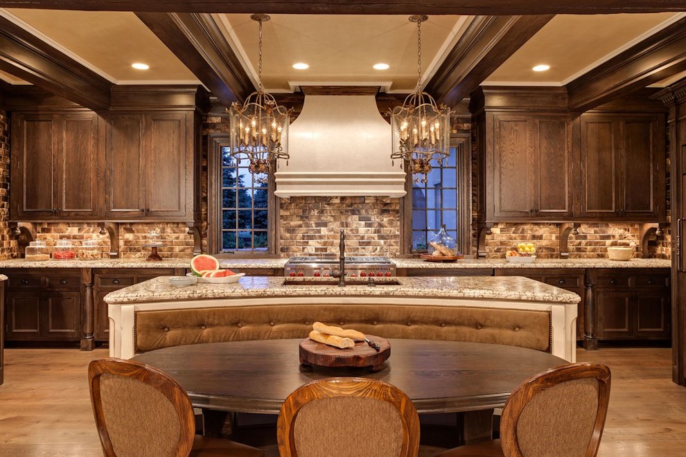 Klassisk inredning av ett kök och matrum, med en undermonterad diskho, luckor med infälld panel, skåp i mörkt trä, flerfärgad stänkskydd, rostfria vitvaror och en köksö