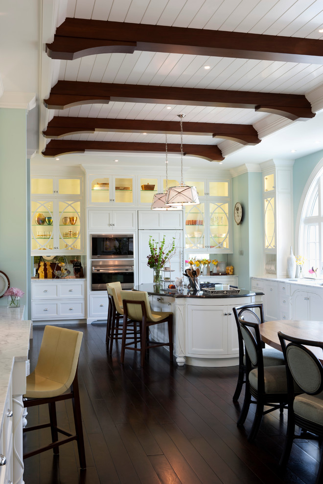 Inspiration for a transitional eat-in kitchen remodel in New York with glass-front cabinets, paneled appliances and white cabinets