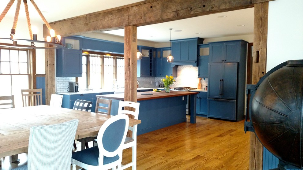 Exempel på ett stort maritimt kök, med en rustik diskho, skåp i shakerstil, blå skåp, träbänkskiva, blått stänkskydd, stänkskydd i tunnelbanekakel, integrerade vitvaror, mellanmörkt trägolv och en köksö