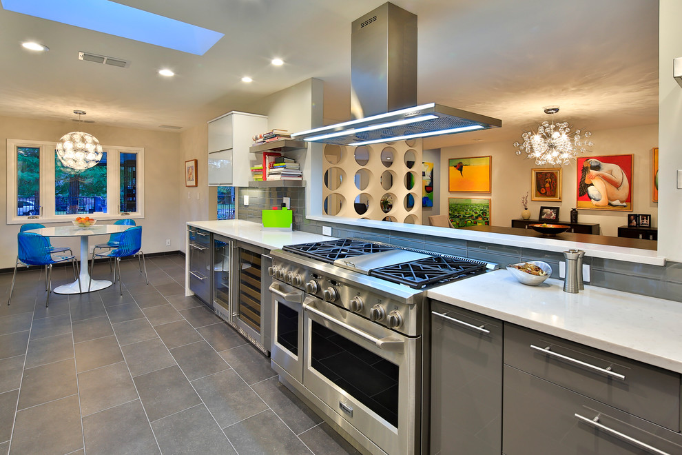 Immagine di una cucina abitabile contemporanea con ante lisce, ante grigie, paraspruzzi grigio e elettrodomestici in acciaio inossidabile