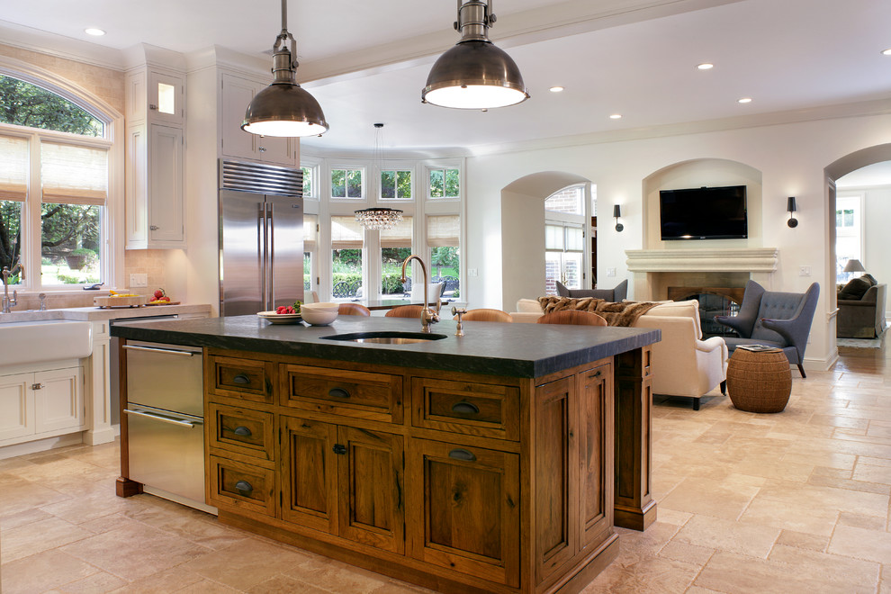 Inspiration for a large transitional l-shaped travertine floor eat-in kitchen remodel in New York with an undermount sink, recessed-panel cabinets, medium tone wood cabinets, beige backsplash, stainless steel appliances and soapstone countertops